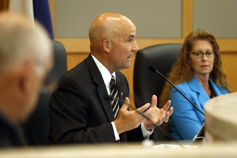 Collin County Judge Keith Self (center) speaks during a hearing during a meeting of the...