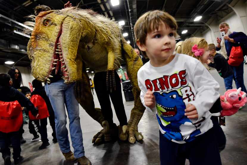 (Boy is unidentified) Boys and girls excitedly run away from an adolescent T-Rex, as a man...
