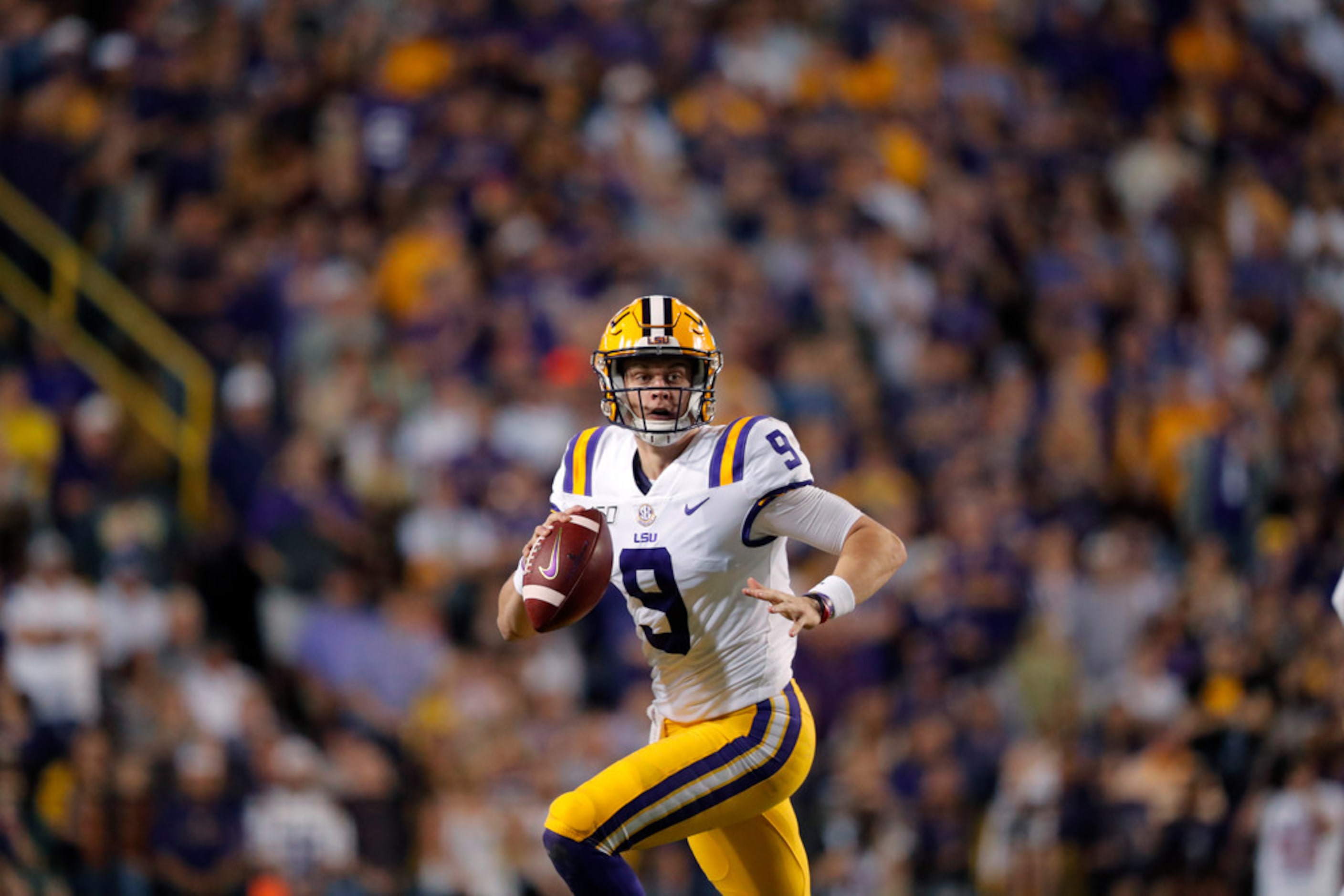 LSU quarterback Joe Burrow (9) scrambles in the first half of an NCAA college football game...