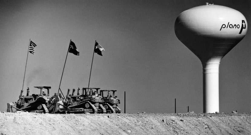  A trio of bulldozers each carrrying a flag, one for the United States, one for J.C. Penney...