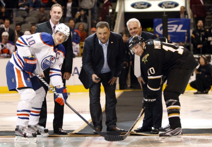 Stars owner Tom Gaglardi drops the first puck with Edmonton center Shawn Horcoff (left) and...