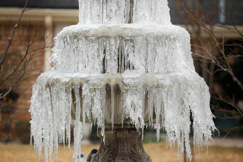 
Ice hangs off a frozen water fountain at a subdivision in Richardson. Temperatures early...