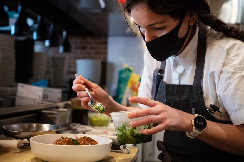 Olivia Lopez plates a dish of chicken pipián 