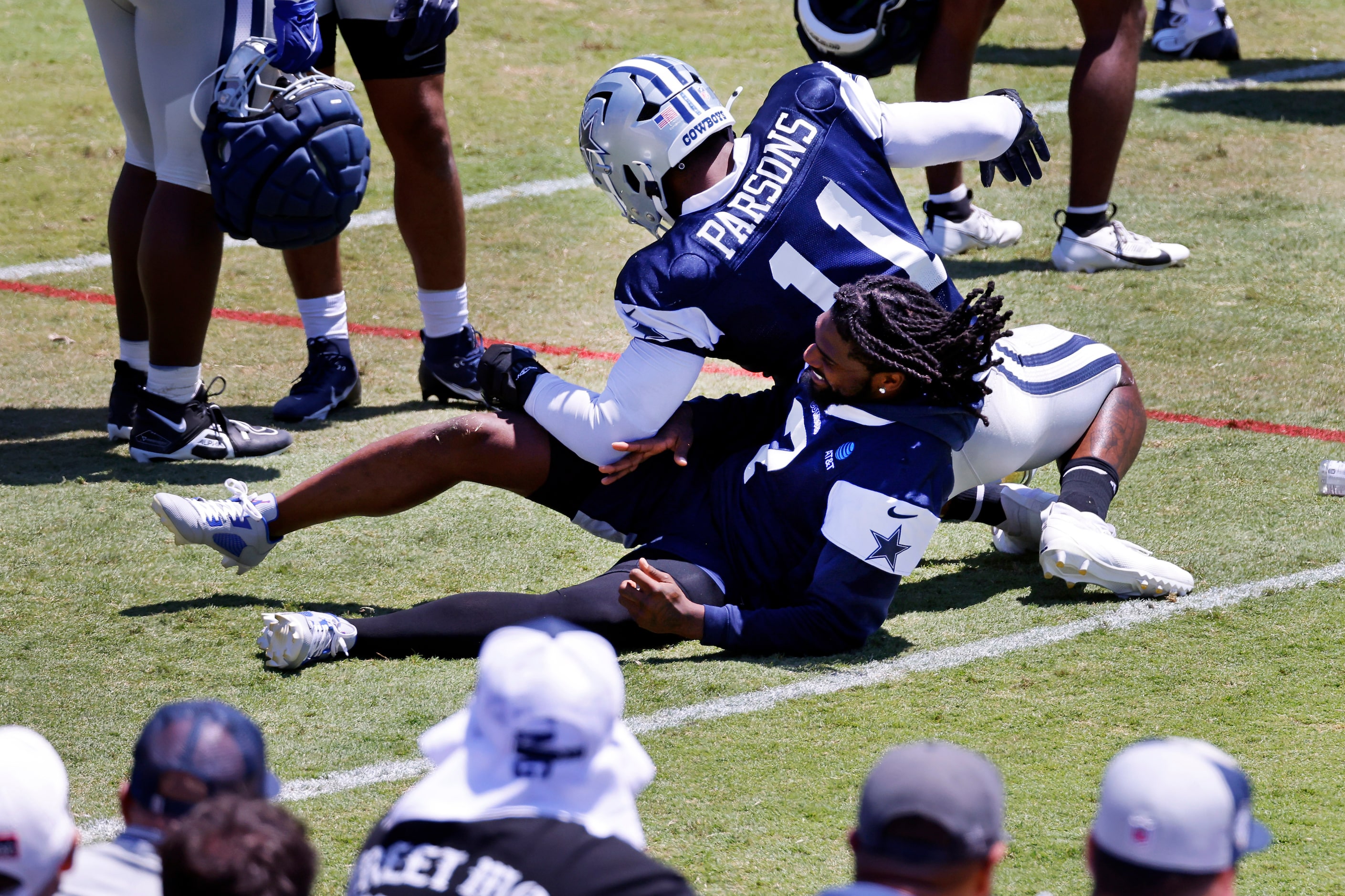 Dallas Cowboys linebacker Micah Parsons (11) drops on top of cornerback Trevon Diggs (7) as...