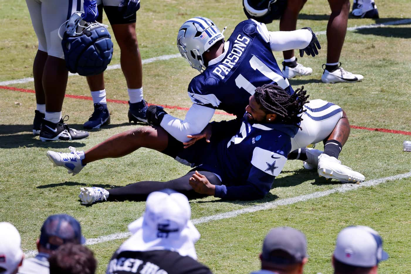 Dallas Cowboys linebacker Micah Parsons (11) drops on top of cornerback Trevon Diggs (7) as...