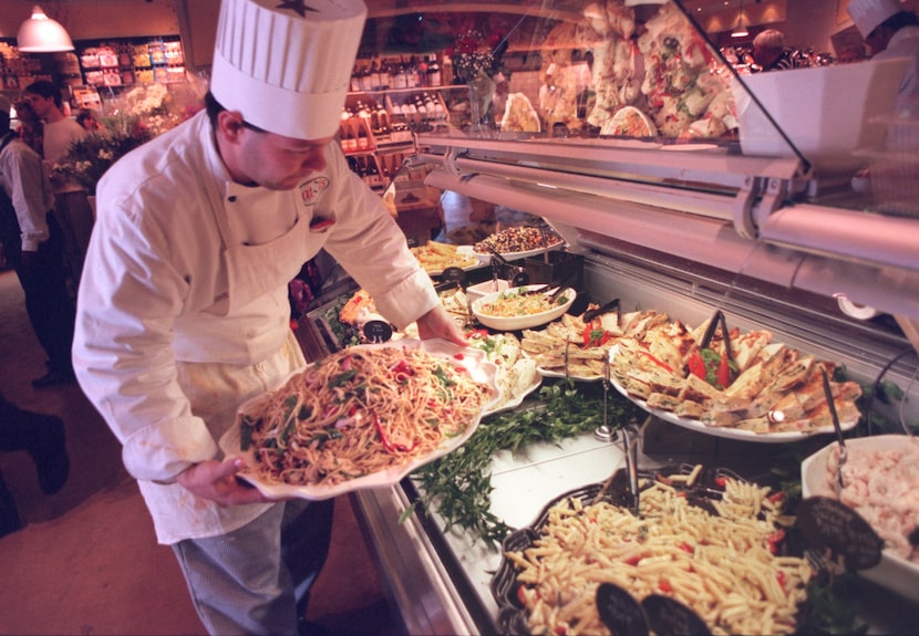 Chef Bill McNeil reloads the take-out food case at Eatzi's in 1996. Little has changed about...