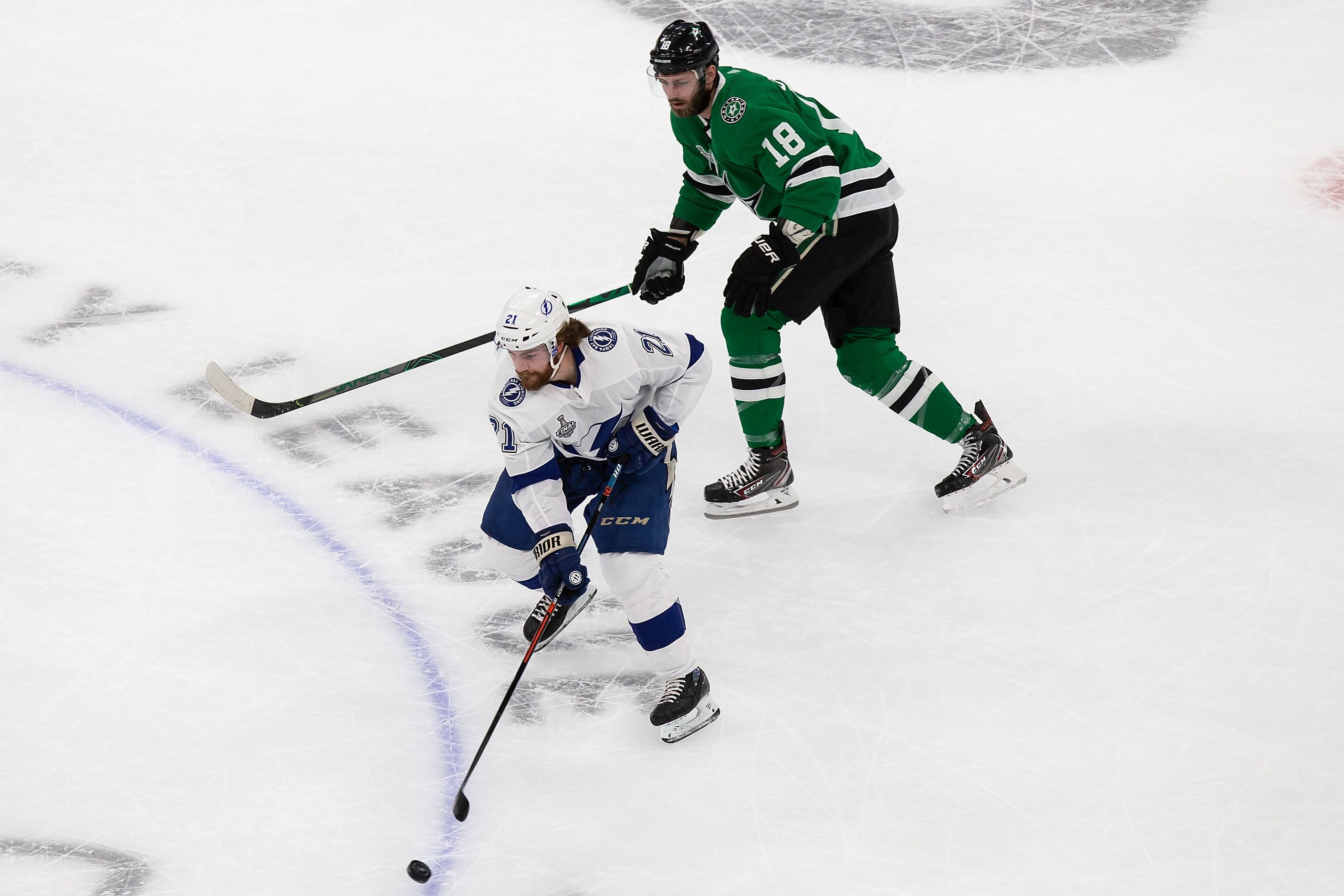 Jason Dickinson (18) of the Dallas Stars pursues Brayden Point (21) of the Tampa Bay...