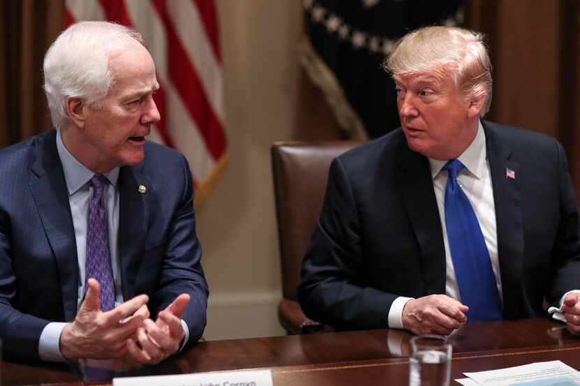 President Donald Trump listens to Sen. John Cornyn during a meeting at the White House on...