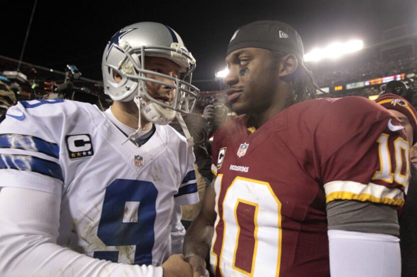 Dallas Cowboys quarterback Tony Romo (9) talks to Washington Redskins quarterback Robert...