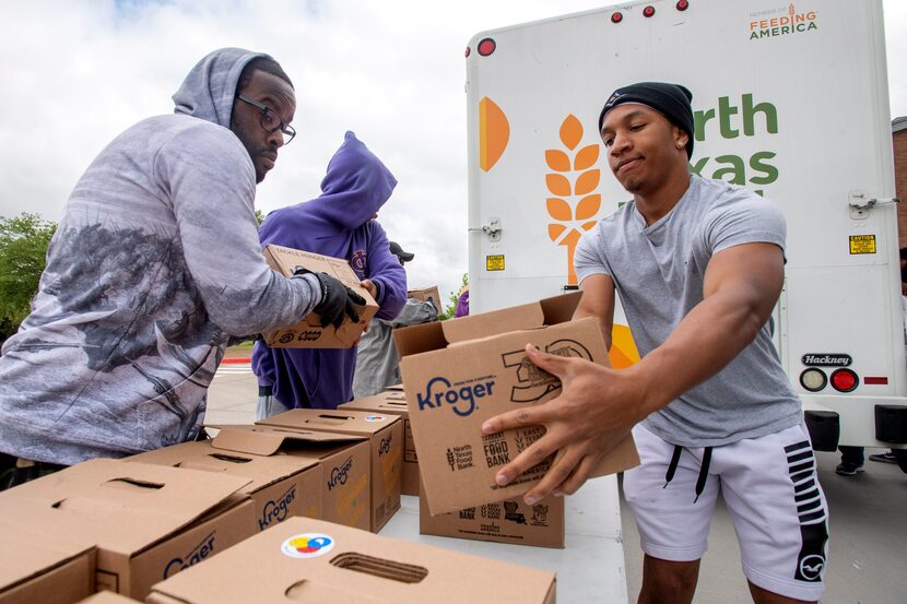 UNT-Dallas student Kevan Wise (right) and alum Darnell Davis unloaded boxes of food from a...