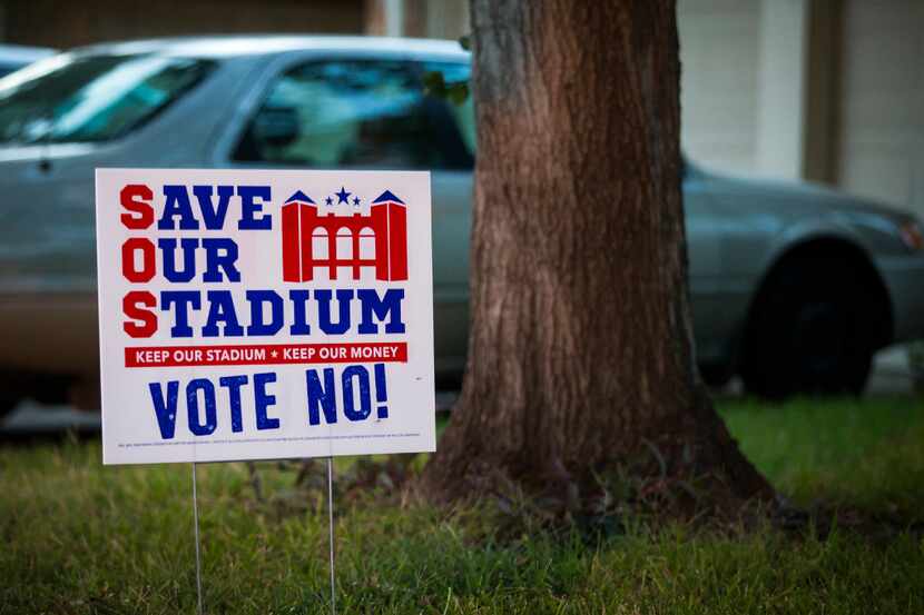 Yard signs express opposition to a proposal to build a $1 billion retractable-roof stadium...
