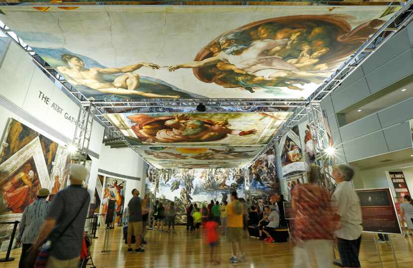 People look at the photo reproduction of the Sistine Chapel that includes 33 panels in an...