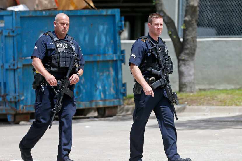 Two Dallas Police Department officers leave an shooting scene outside an office building in...