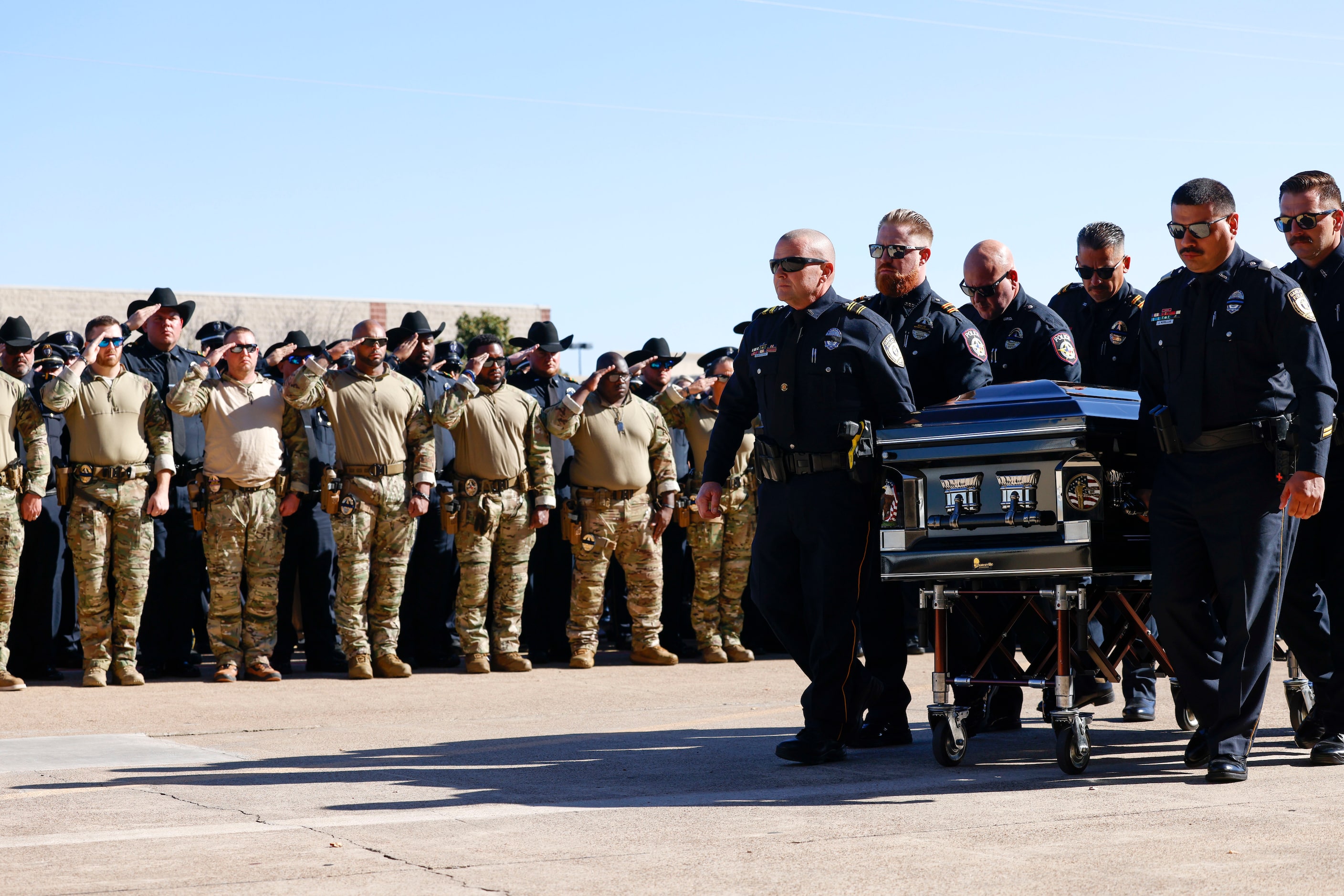 The casket of Greenville police officer Cooper Dawson is escorted by members of law...