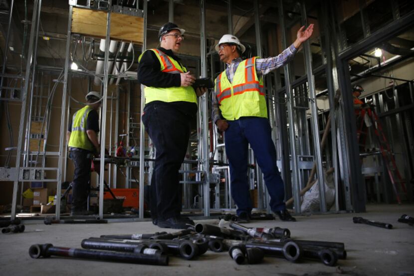Using his iPad, Dallas Senior Building Inspector Joel Cruce (left) conducted an inspection...