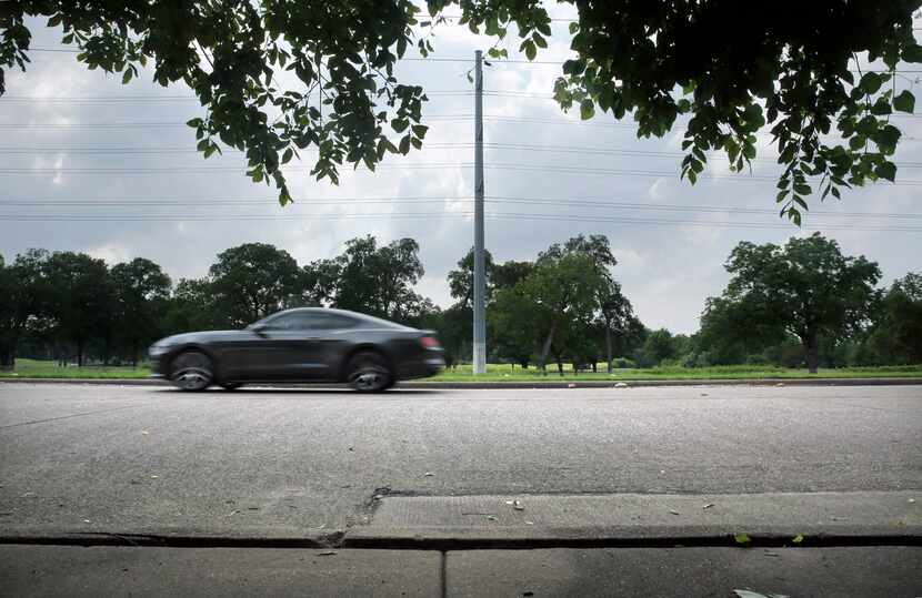 A car passes by the spot on Valley Glen Dr. (foreground) where Muhlaysia Booker's body was...