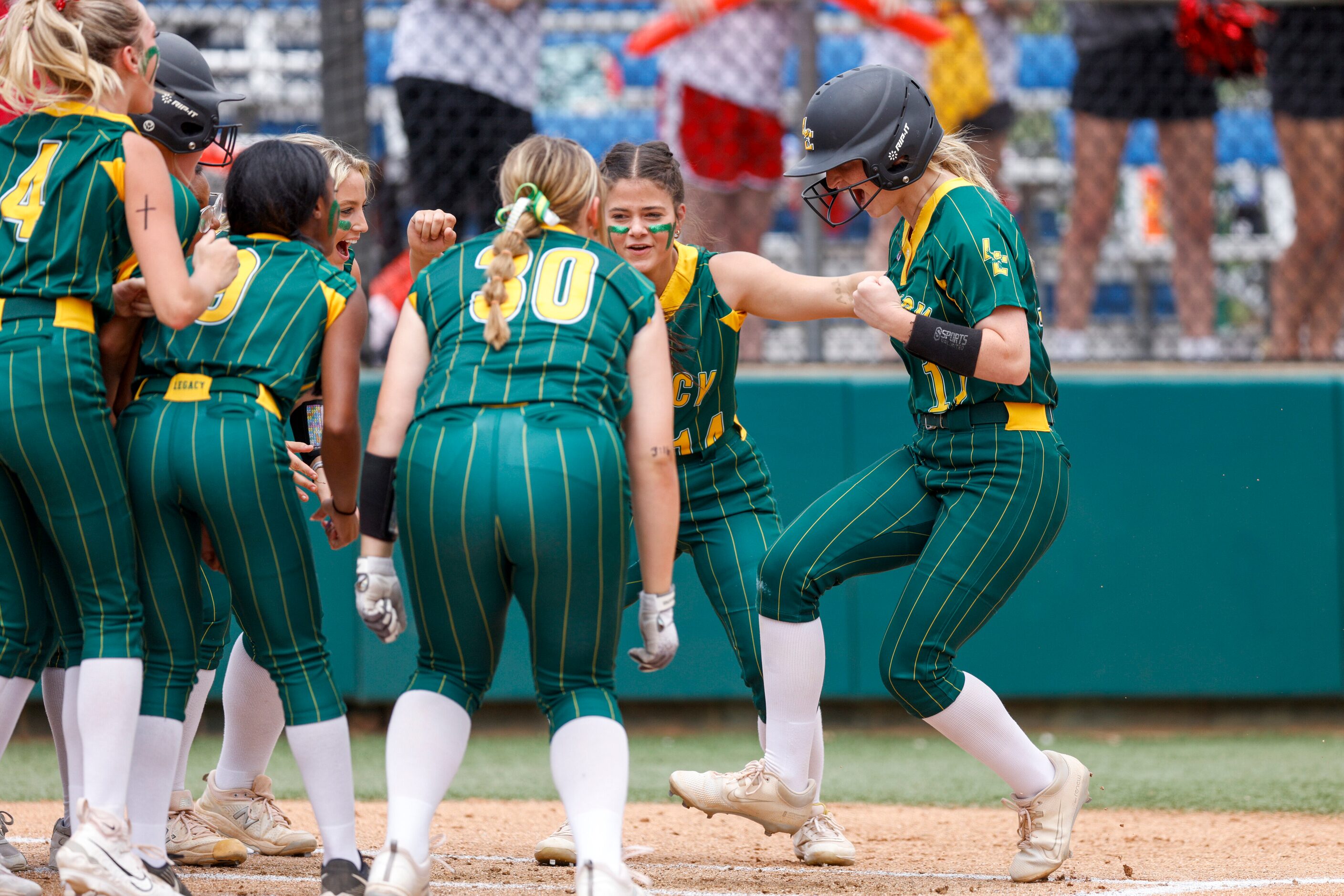 Frisco Legacy Christian catcher Jackie Purtell (right) touches home plate as she’s swarmed...