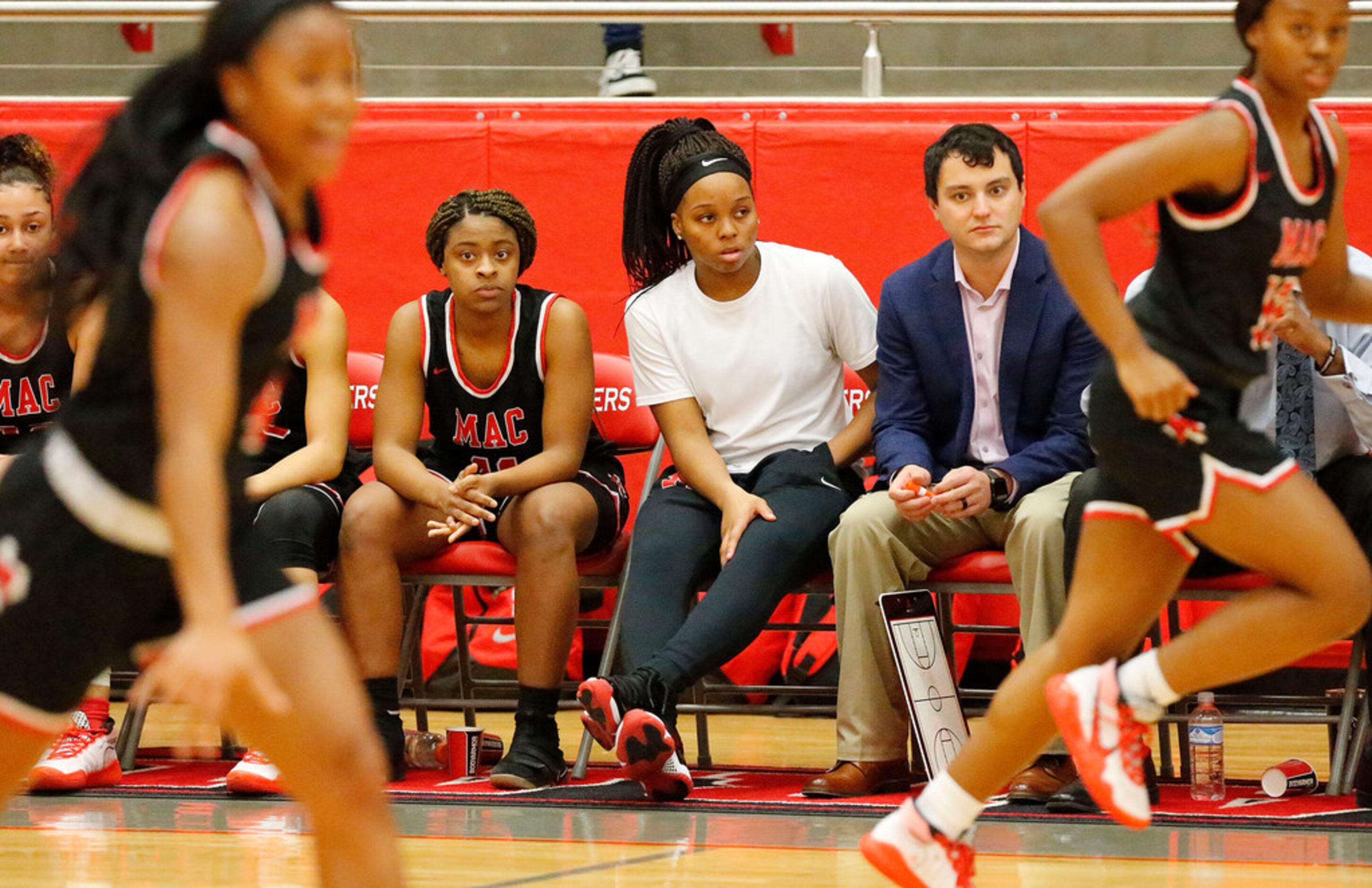 Irving MacArthur High School guard Sarah Andrews (not dressed out) sits on the bench...