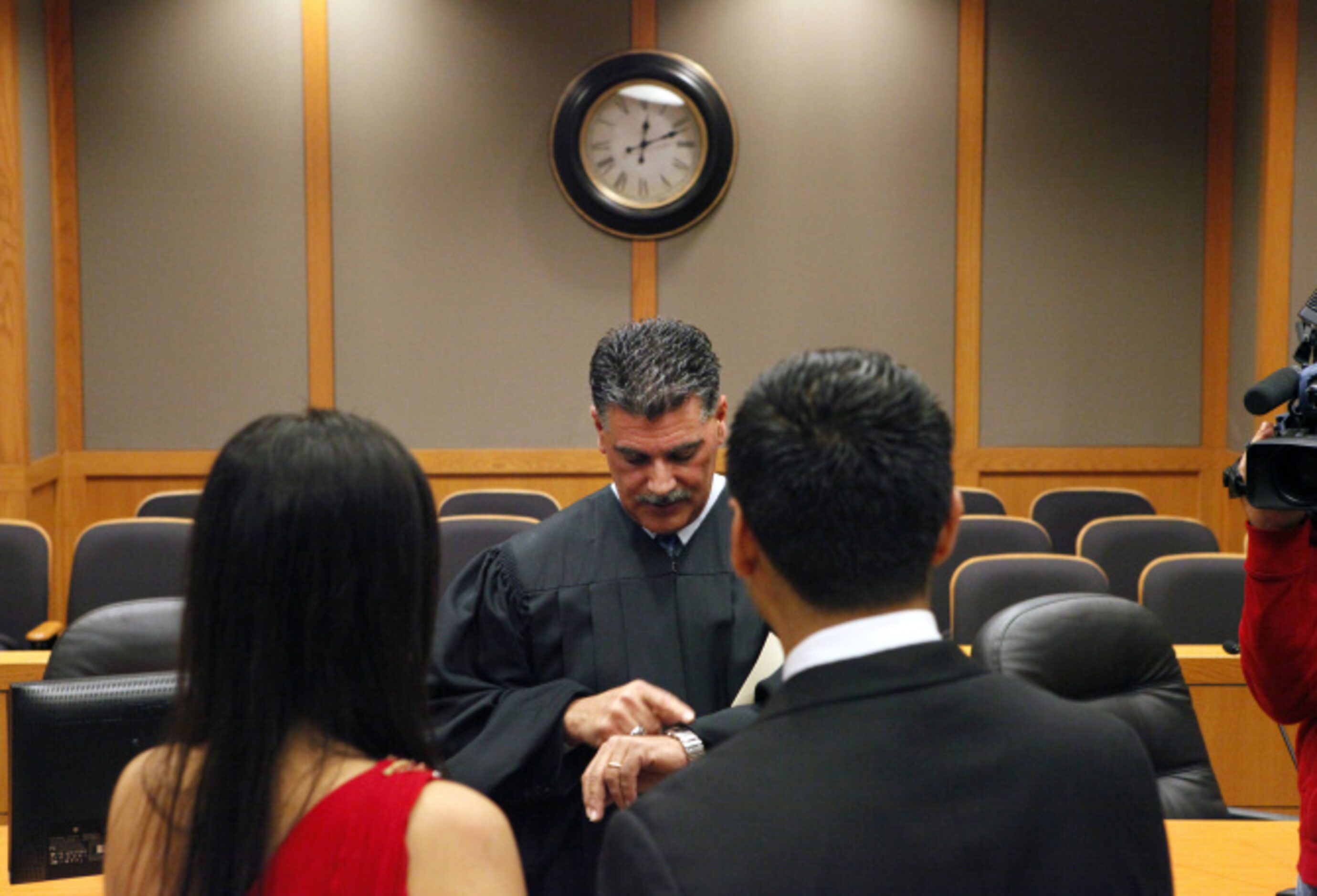 Justice of the Peace Paul Raleeh looks at his watch to announce that Anand and Anita...