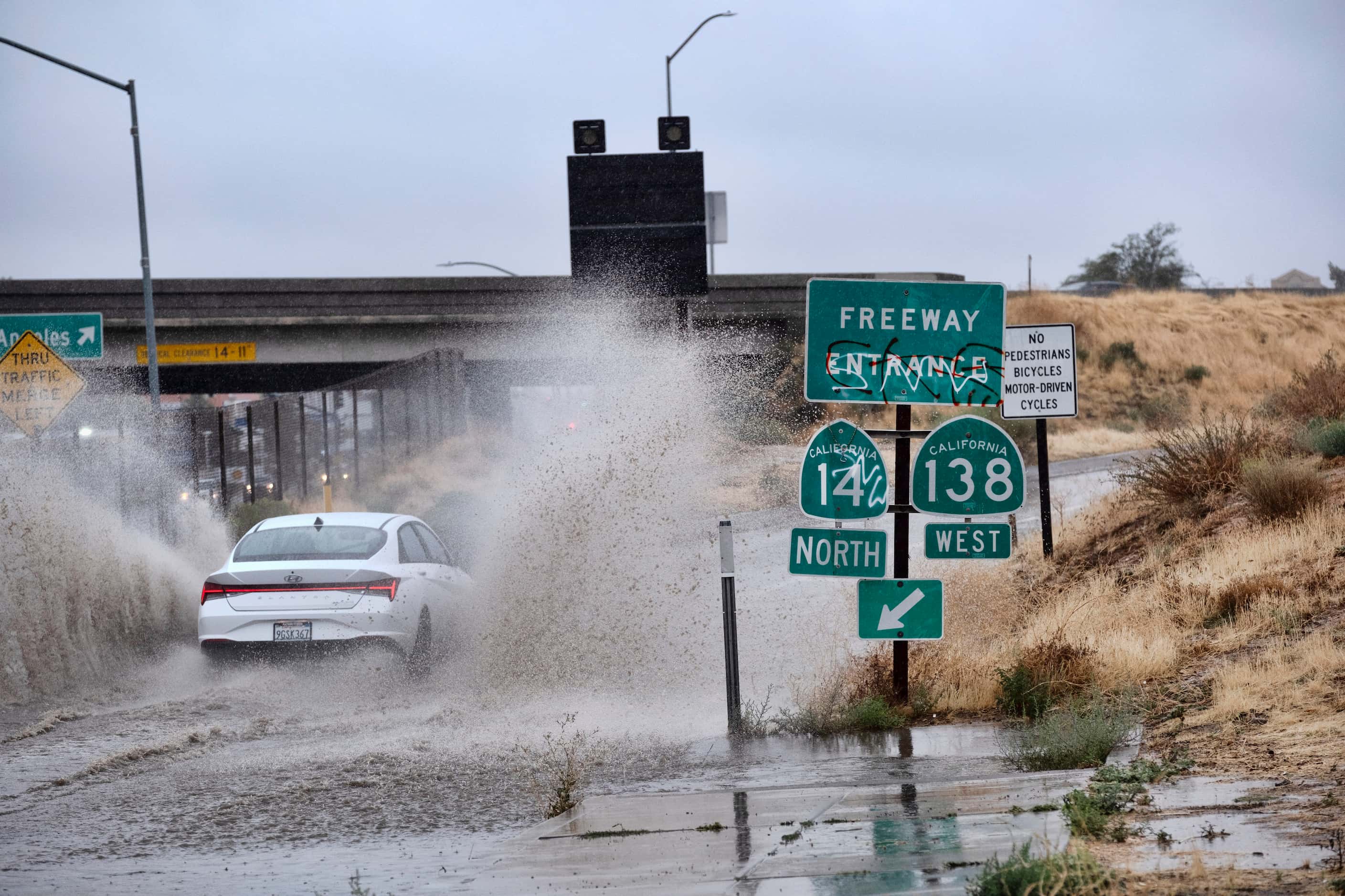 Un vehículo recorre un camino inundado durante el paso de la tormenta tropical Hilary, el...