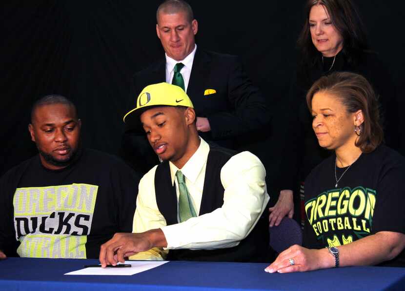 Justin Hollins, who played for Martin High School in Arlington, signs a letter of intent to...