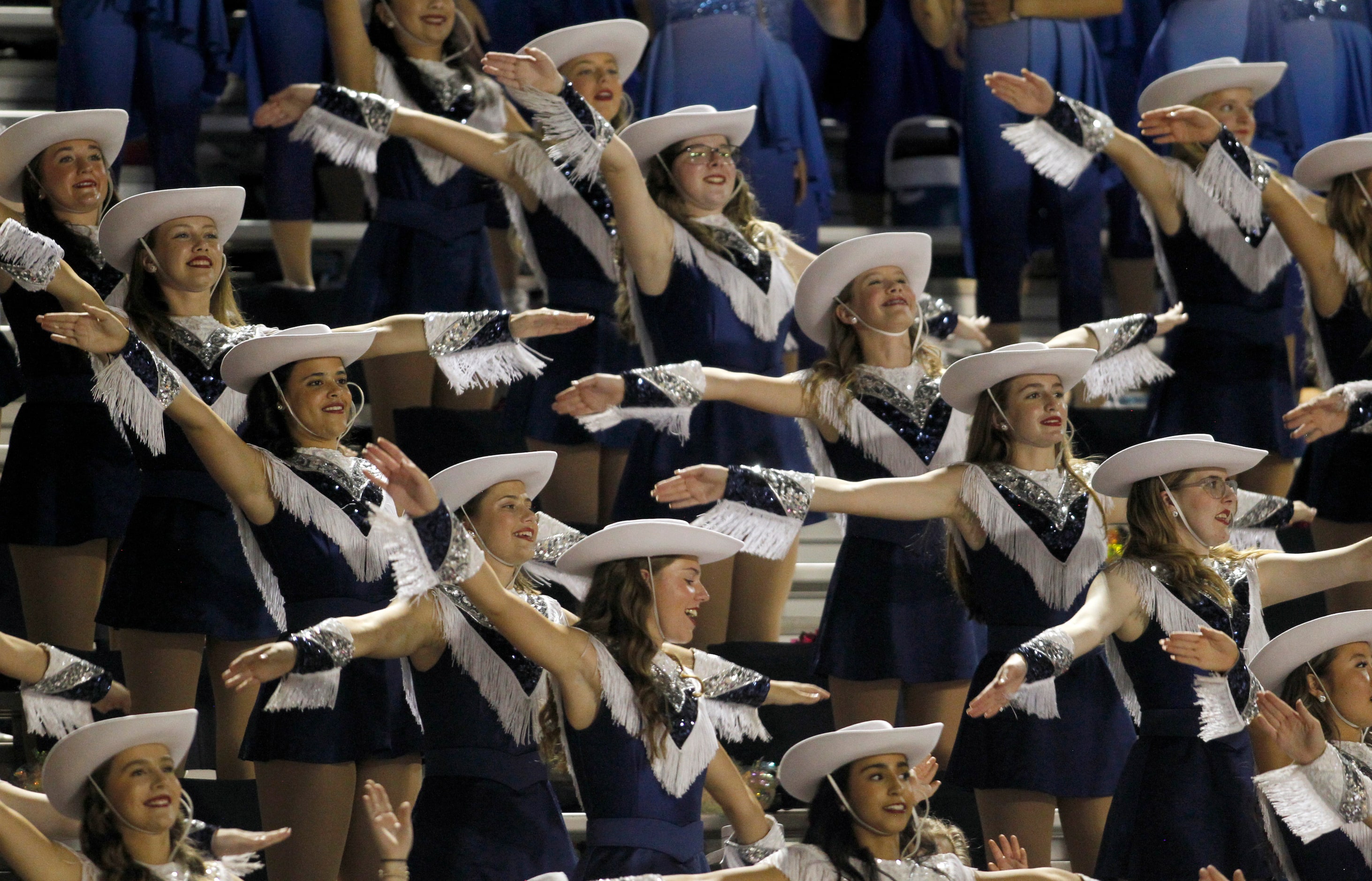 Members of the Flower Mound drill team perform from the stands during first half action of...