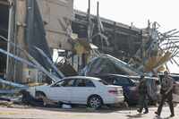 Law enforcement authority members scout a heavily damaged Shell gas station, on Sunday, May...