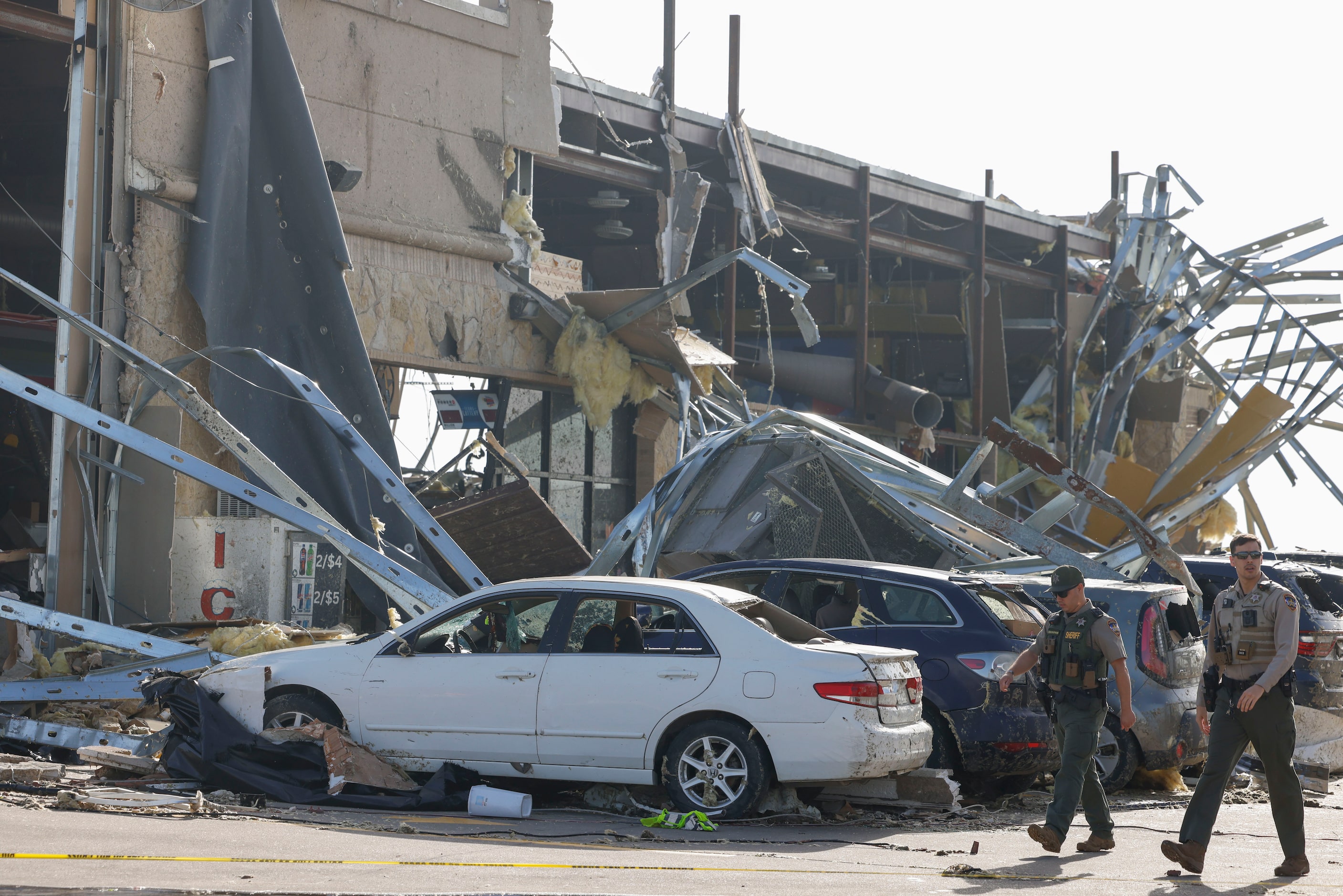 Law enforcement authority members scout a heavily damaged Shell gas station, on Sunday, May...