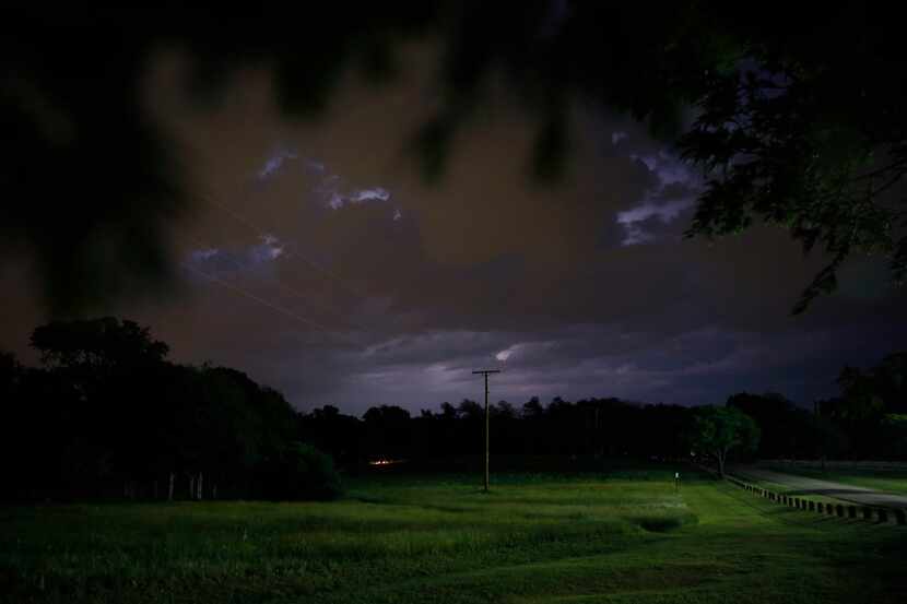 A lightning storm is seen to the northeast from Winfrey Point near White Rock Lake in Dallas...