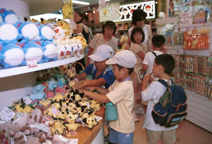 August 23, 2000, Tokyo Children hold stuffed dolls of different Pocket Monsters in Pokemon...