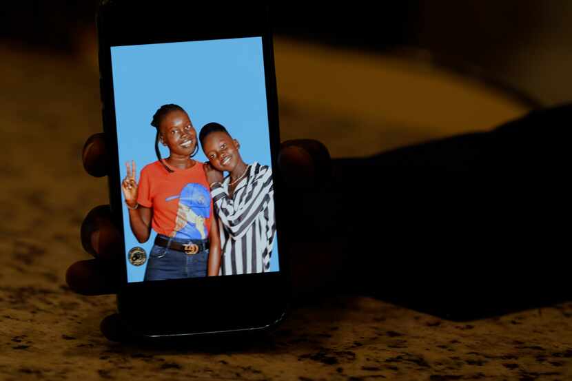 Jacob Mabil shows a cellphone photo of his nieces Nyanluak Deng (left) and Anyier Deng....