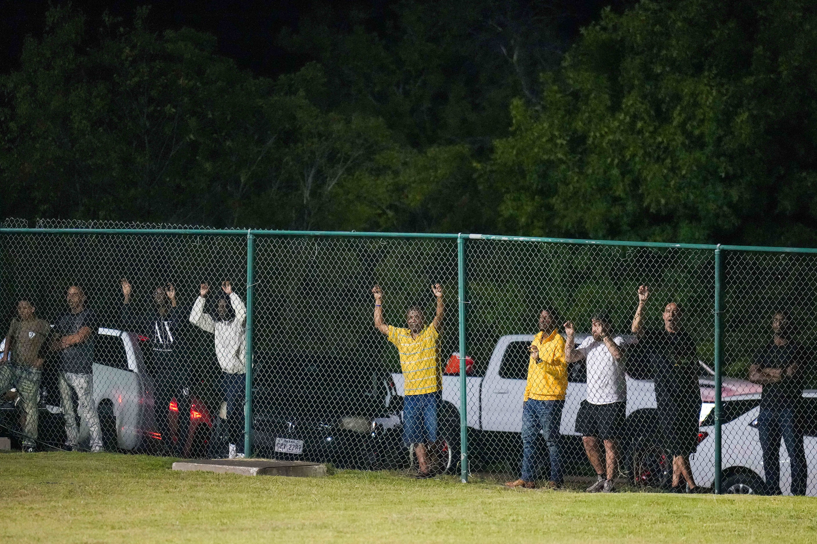 Spectators watch from outside the fences of the stadium during the second half of a sold out...