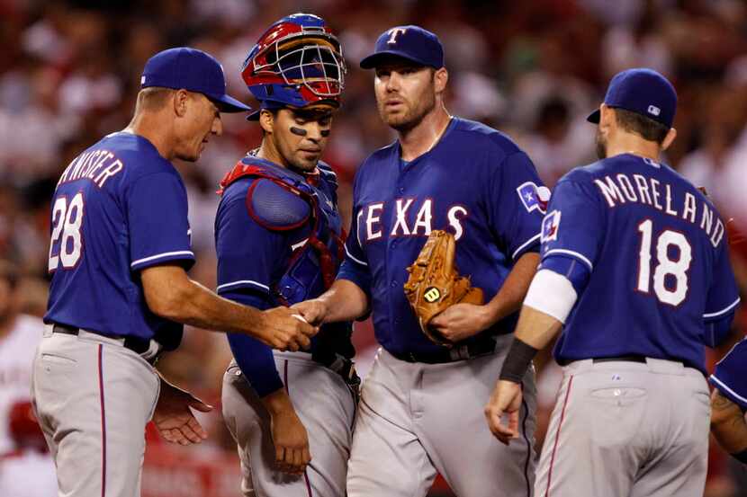 Texas Rangers manager Jeff Banister, left, removes starting pitcher Colby Lewis, second from...