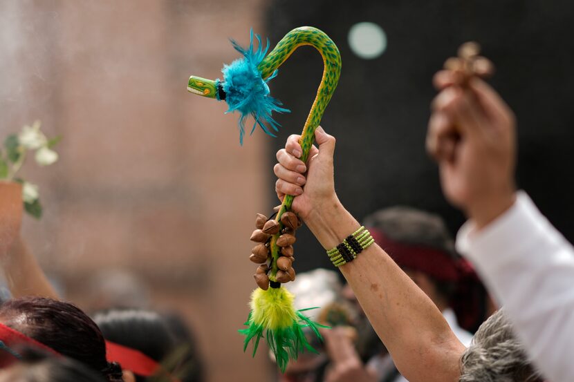 Una persona sostiene una figura de la serpiente emplumada Quetzalcóatl durante una ceremonia...