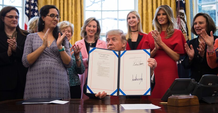 US President Donald Trump (C) signs H.R. 321 in the Oval Office at the White House in...