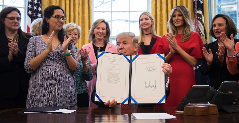 US President Donald Trump (C) signs H.R. 321 in the Oval Office at the White House in...