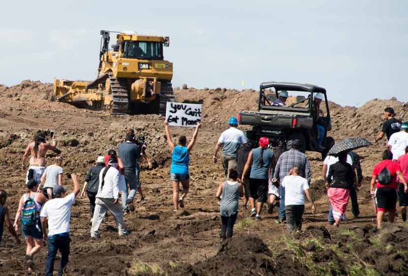 Native American protestors and their supporters are confronted by security during a...