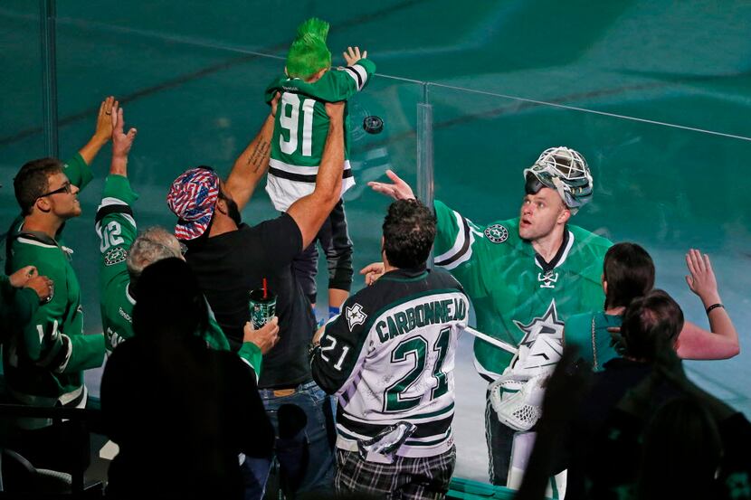 Dallas Stars goalie Antti Niemi (31) flips a puck to a young fan after Niemi was named the...