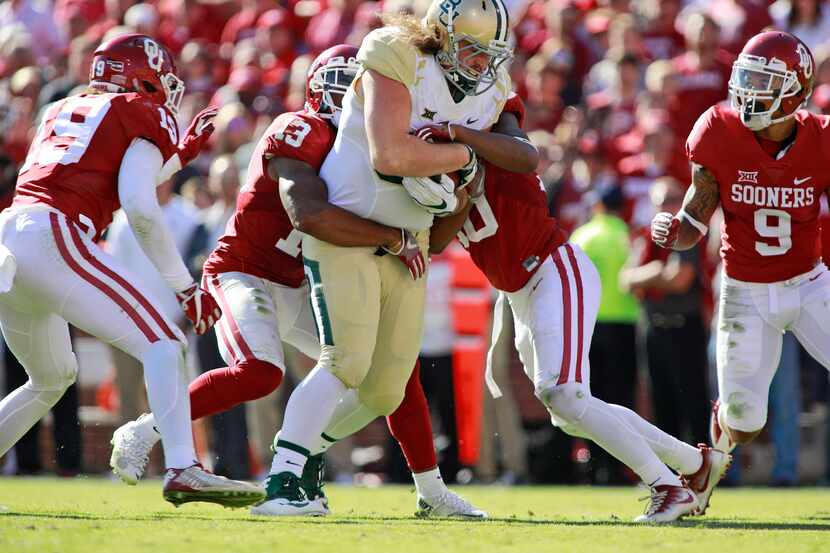 NORMAN, OK - NOVEMBER 12:  The Oklahoma Sooners defense tries to take down tight end Sam...