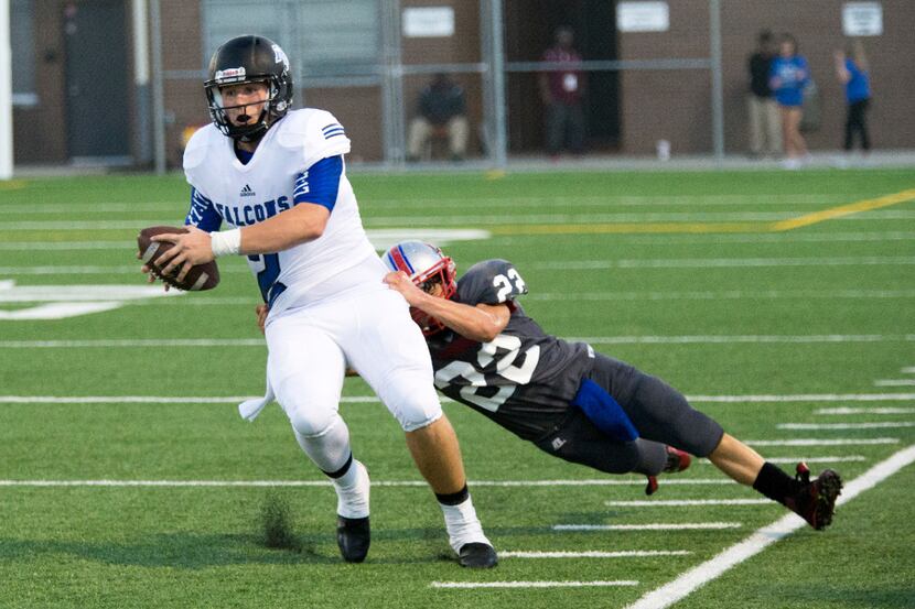 North Forney quarterback Colby Suits (2) is pulled out of bounds by Spruce linebacker...