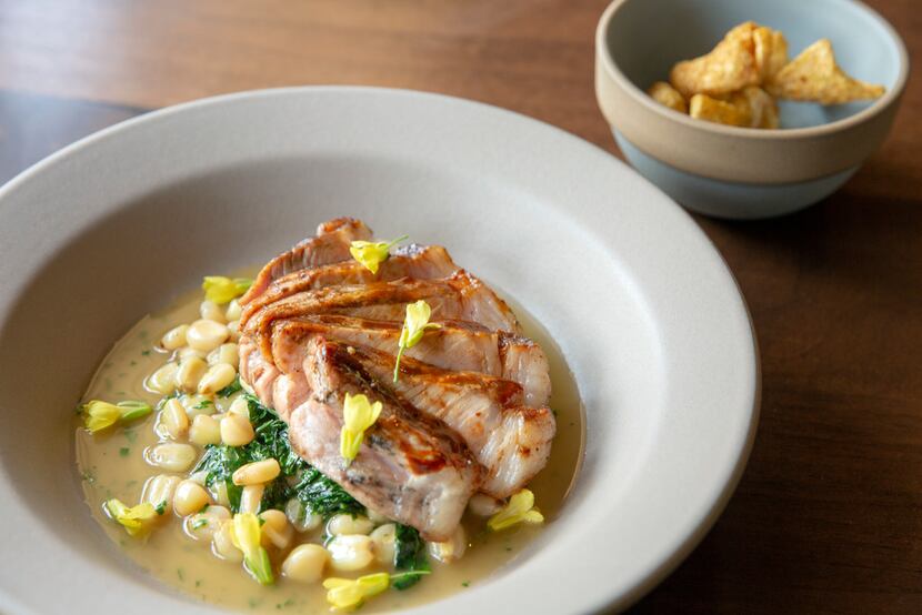 Oak-smoked Hereford pork loin with spigarello, hominy and toasted peanut jus, plus a bowl of...