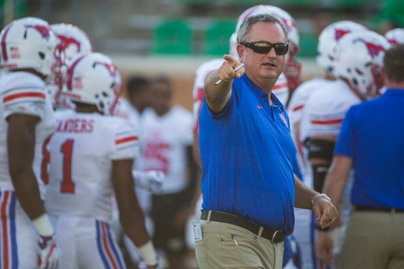 Southern Methodist Mustangs head coach Sonny Dykes works with players during warm ups prior...