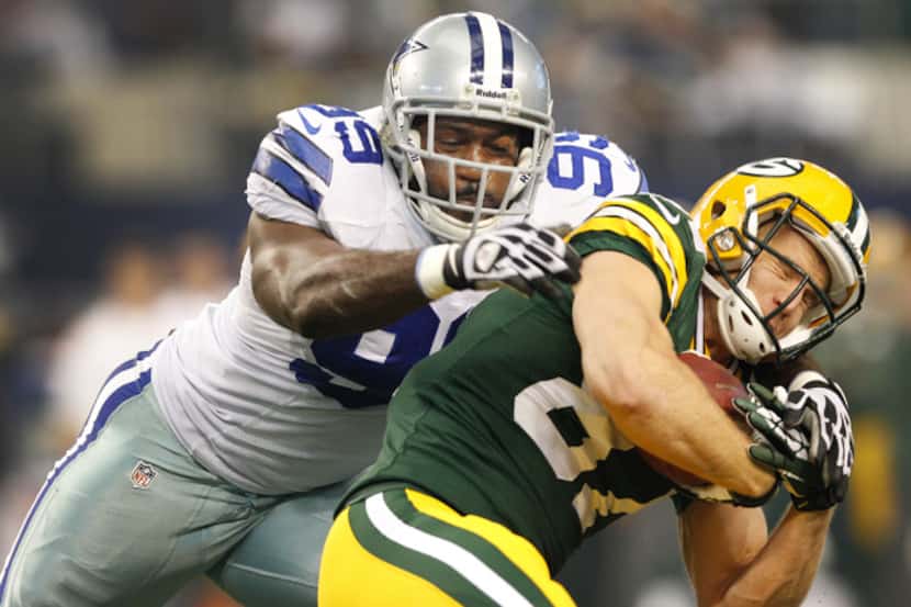 Dallas Cowboys defensive end George Selvie (99) puts the hit on Green Bay Packers wide...