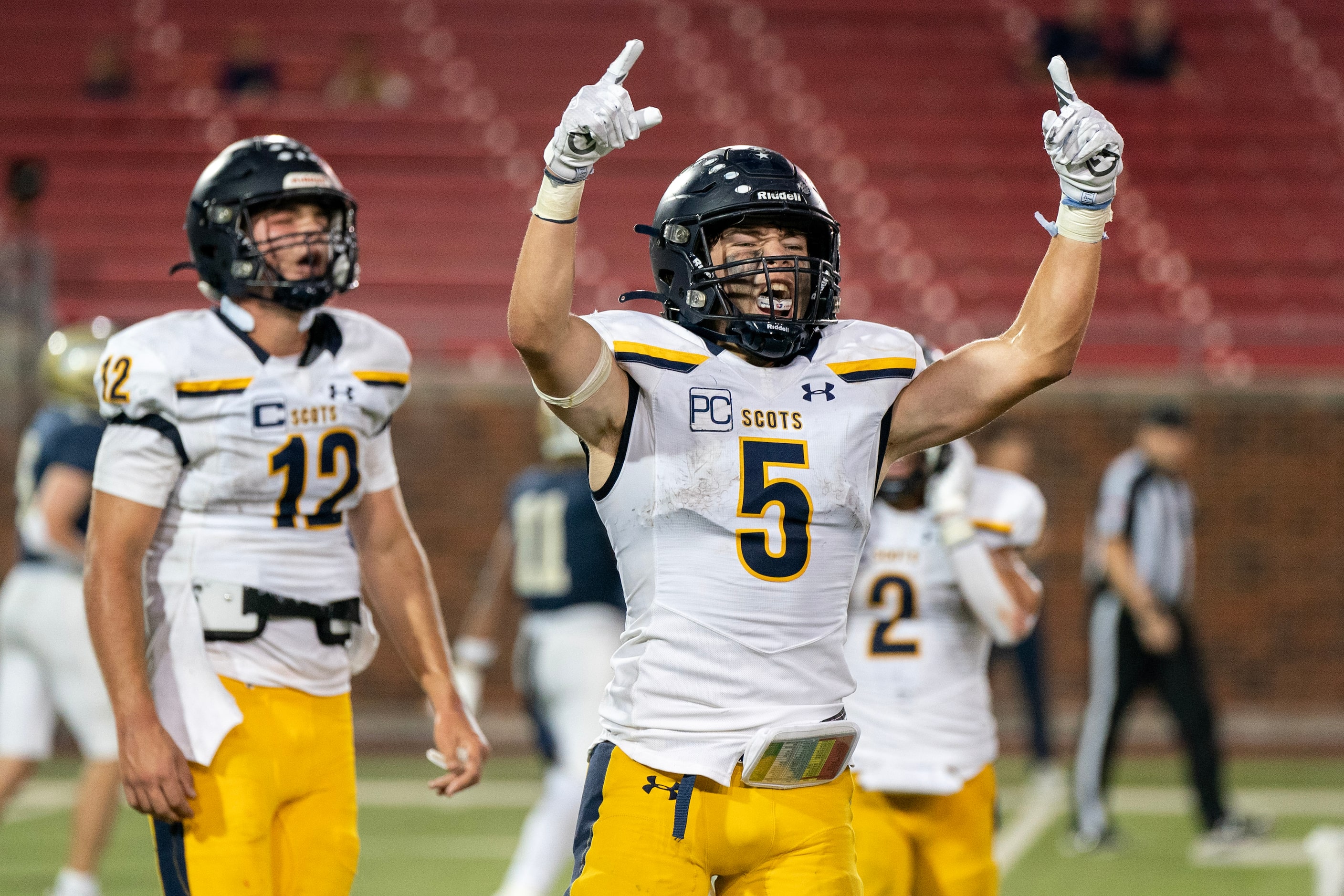 Highland Park senior running back Keller Holmes (5) and senior quarterback Warren Peck (12)...