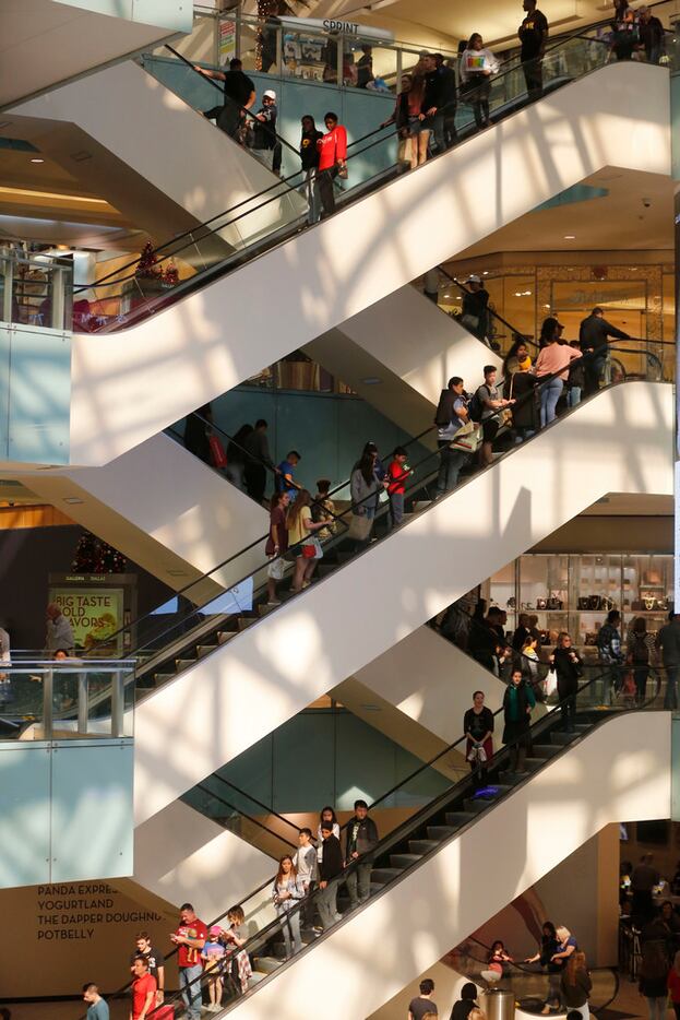 Customers ride up and down the escalators at Galleria Dallas on Nov. 23, 2018. (Nathan...