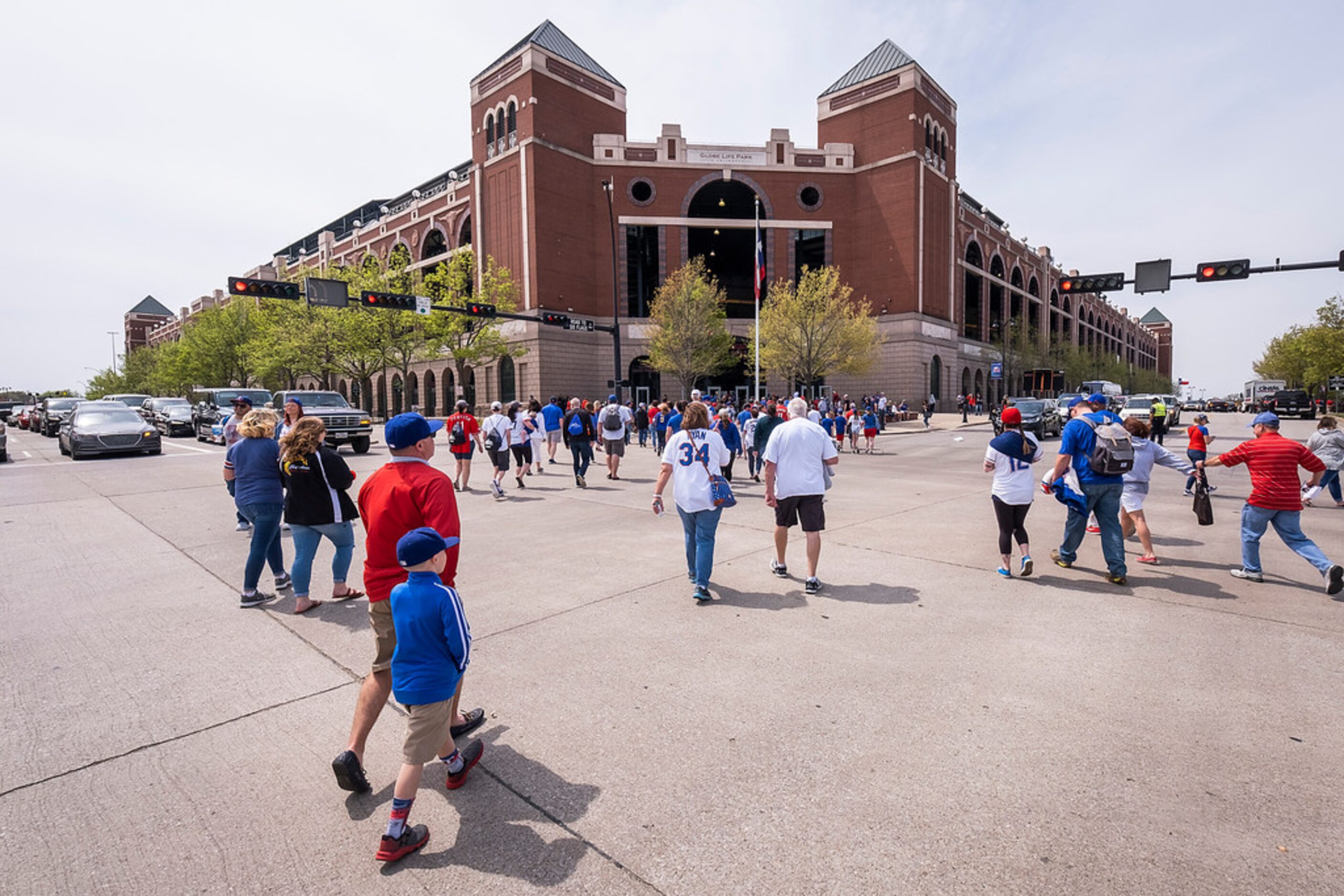 Fans head for the stadium for the Texas Rangers opening day game against the Chicago Cubs at...