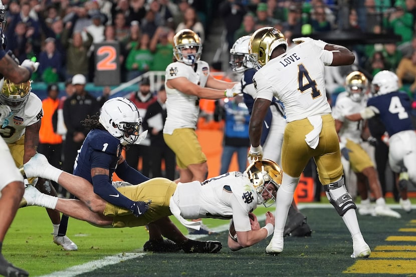 Penn State safety Jaylen Reed (1) attempts to hold Notre Dame quarterback Riley Leonard (13)...