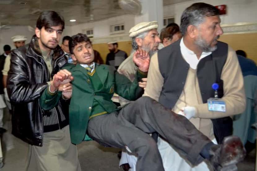 
Volunteers carried an injured student into a hospital in Peshawar, Pakistan, on Tuesday...