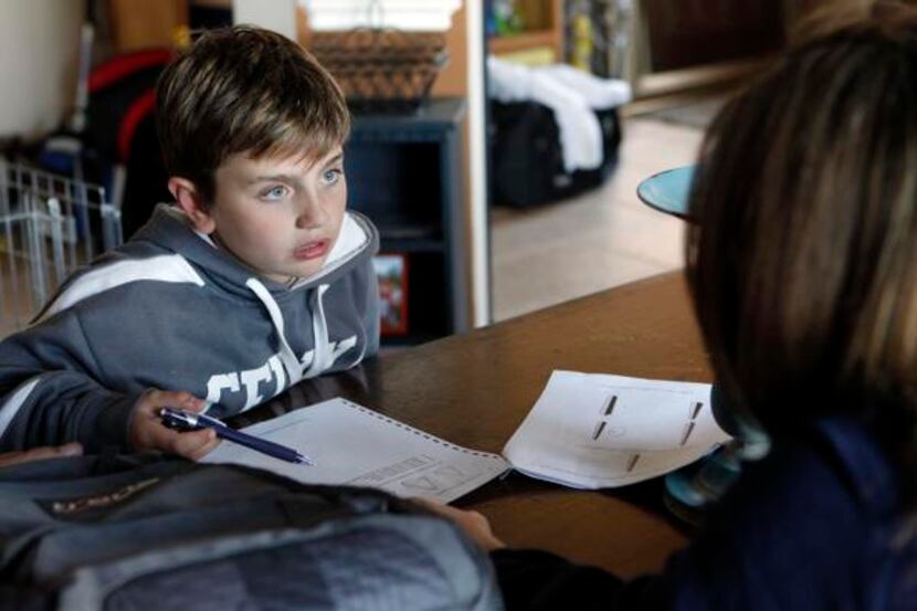 
Maeve Siano helps her daughter, Delaney Siano, 8, with her homework at their home in...