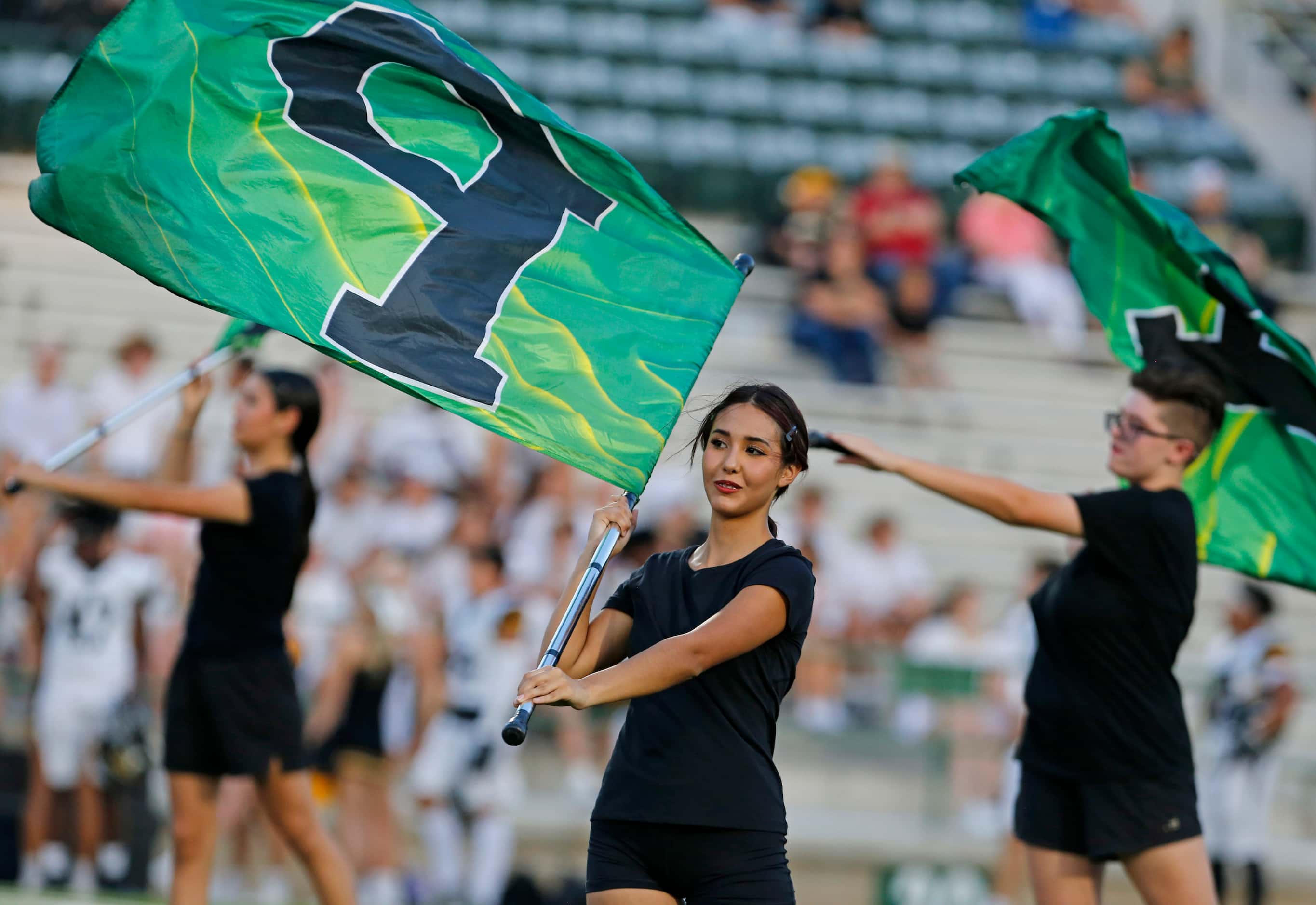 Mesquite Poteet flag squad members perform before the start of the first half of a high...